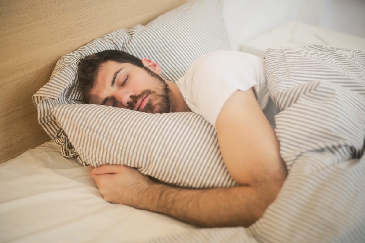 Person sleeping peacefully after treating sleep apnea through weight loss and lifestyle changes