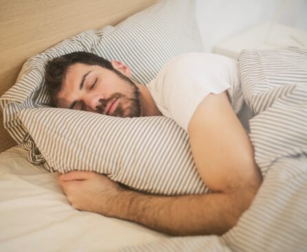 Person sleeping with clock showing optimal sleep duration to prevent brain and organ aging