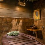 Person entering cold plunge ice bath after sauna for contrast therapy recovery