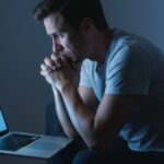 Person anxiously searching symptoms online late at night, illustrating health anxiety